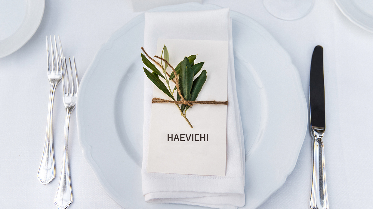 Napkin, leaves and Haevichi logo on a white plate