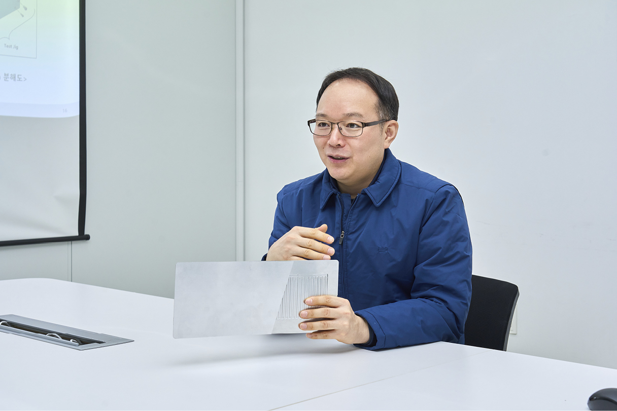 Researcher Explains With Heat Pipe in His Hand