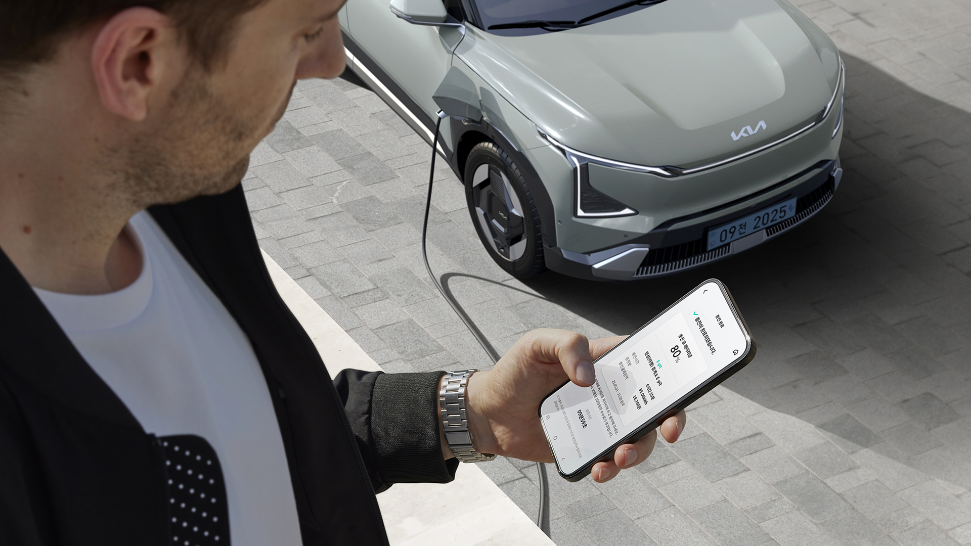 스마트폰으로 전기차 충전을 확인하는 모습