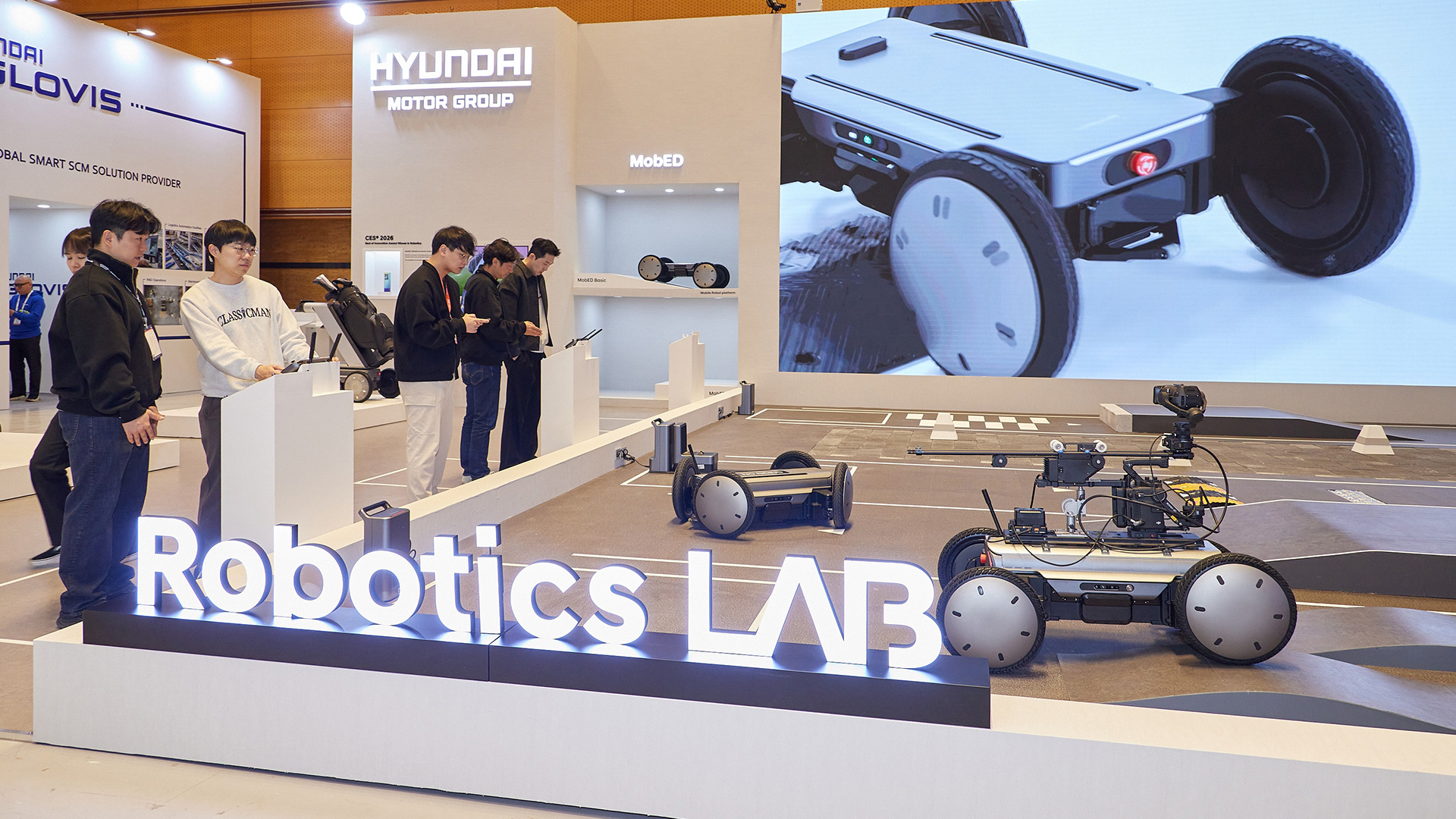 AW2026 전시장 내 현대차·기아 로보틱스랩 부스에서 관람객들이 모베드를 직접 체험 조작하는 모습