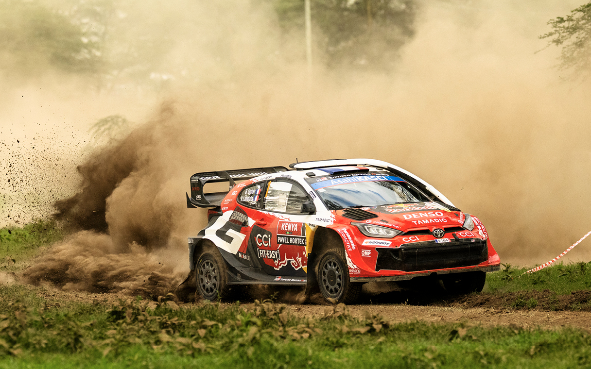 A Toyota rally car runs through the grasslands of safari