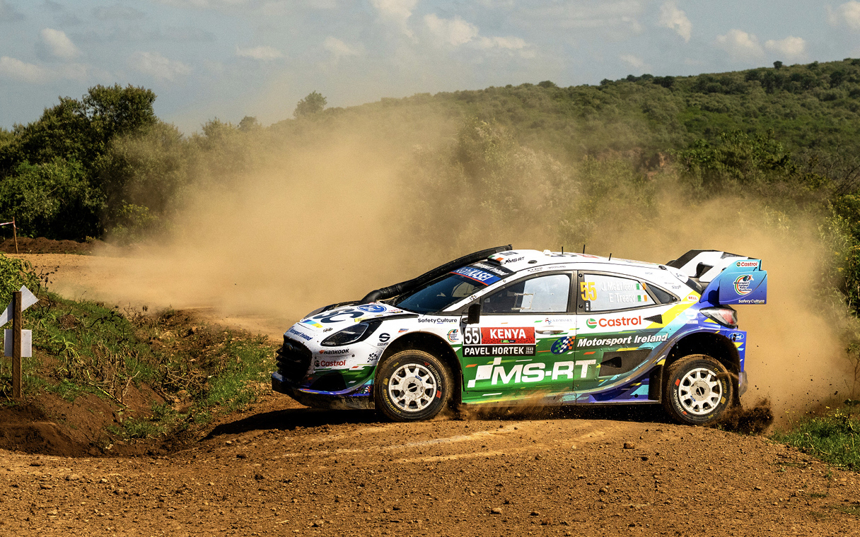 A Ford Puma rally car runs through the grasslands of safari