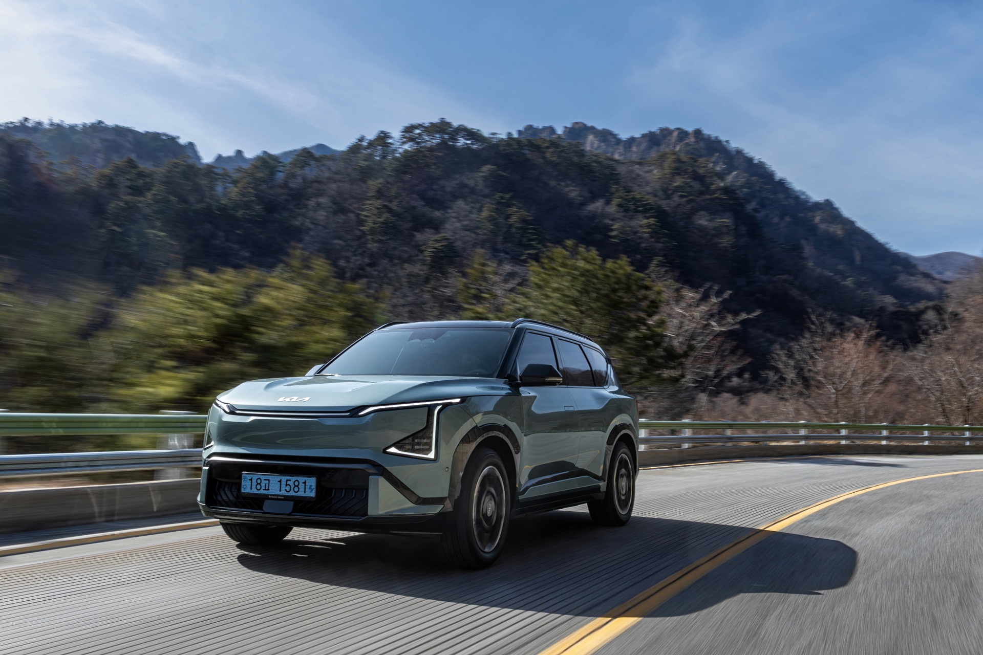 탁 트인 도로와 맑은 하늘 아래, 선명하게 드러나는 기아 EV5 GT-Line의 볼드한 실루엣.