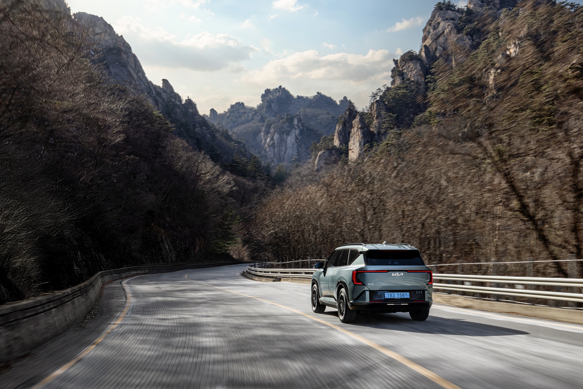 탁 트인 도로와 맑은 하늘 아래, 선명하게 드러나는 기아 EV5 GT-Line의 볼드한 실루엣.