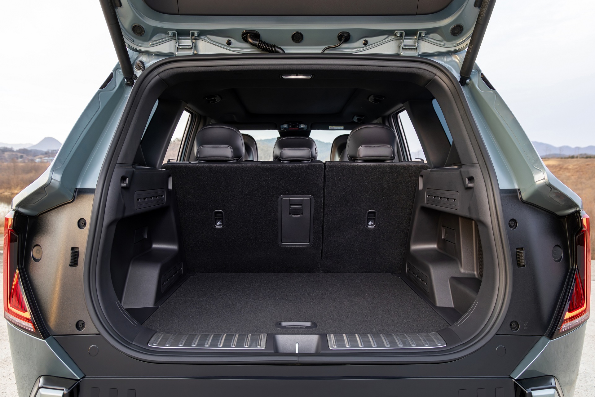 탁 트인 도로와 맑은 하늘 아래, 선명하게 드러나는 기아 EV5 GT-Line의 볼드한 실루엣.