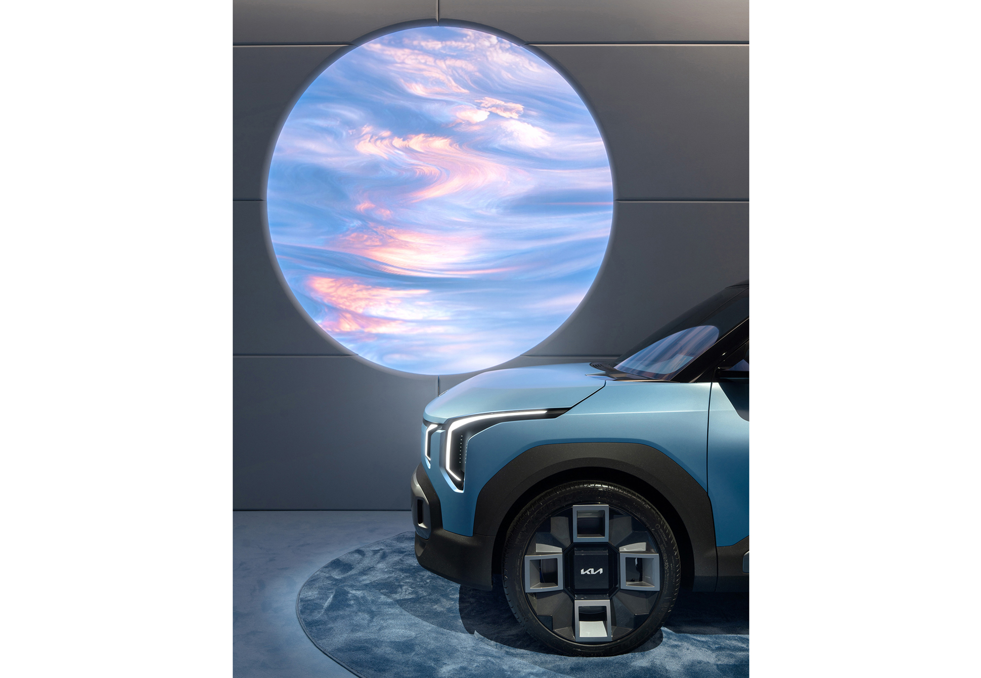 차량 앞 유리에 원형 디지털 그래픽이 투영된 전시 연출 장면 (EV2)