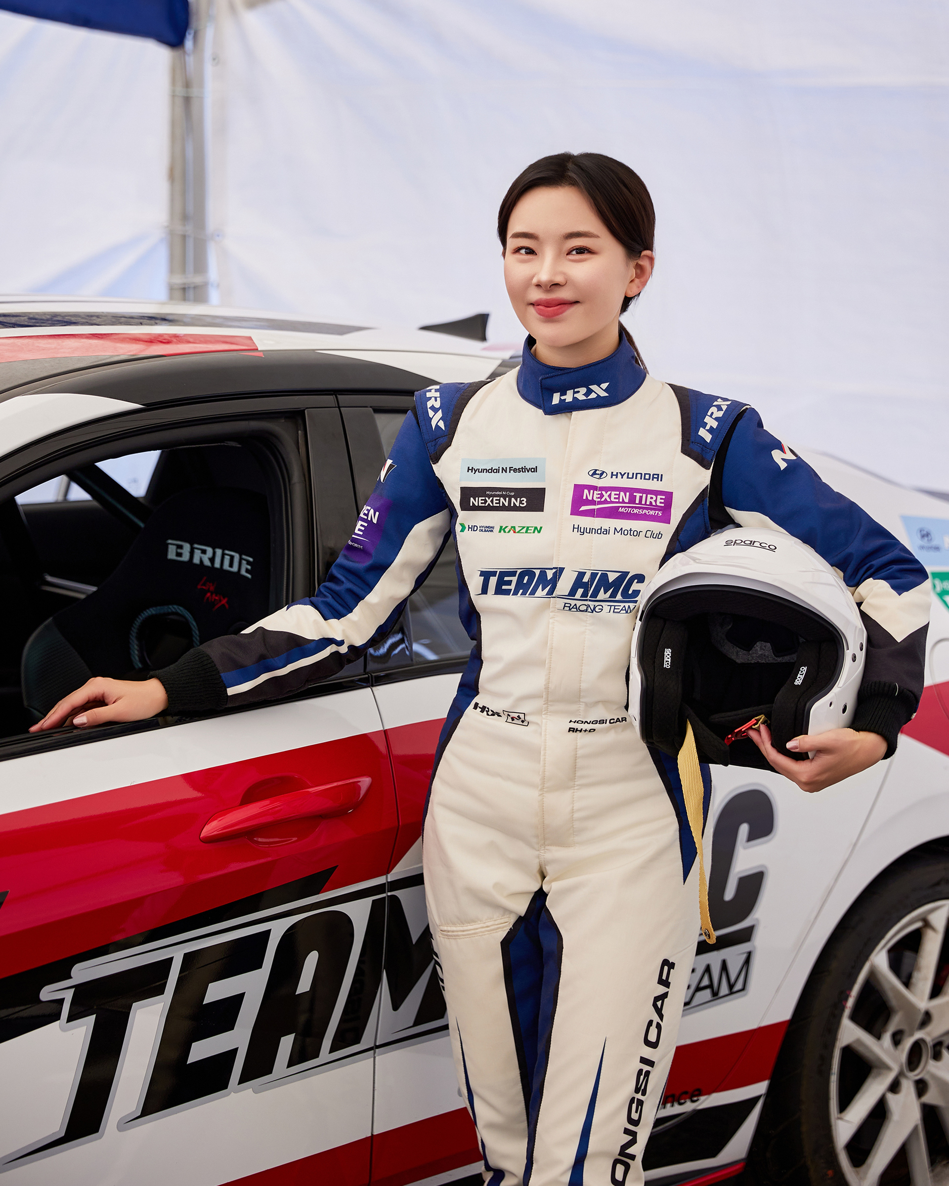 차량 앞에서 포즈를 취하는 홍시카 선수의 모습