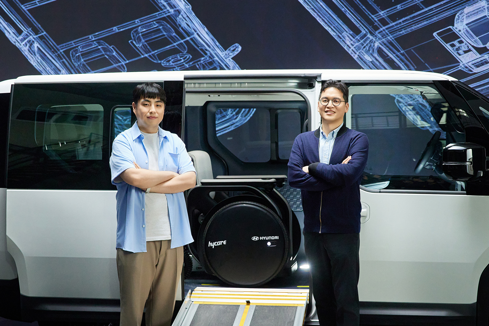 Yoo Han-soo (left) and Han Jeong-ho (right) posing in front of the Kia PV5 WAV