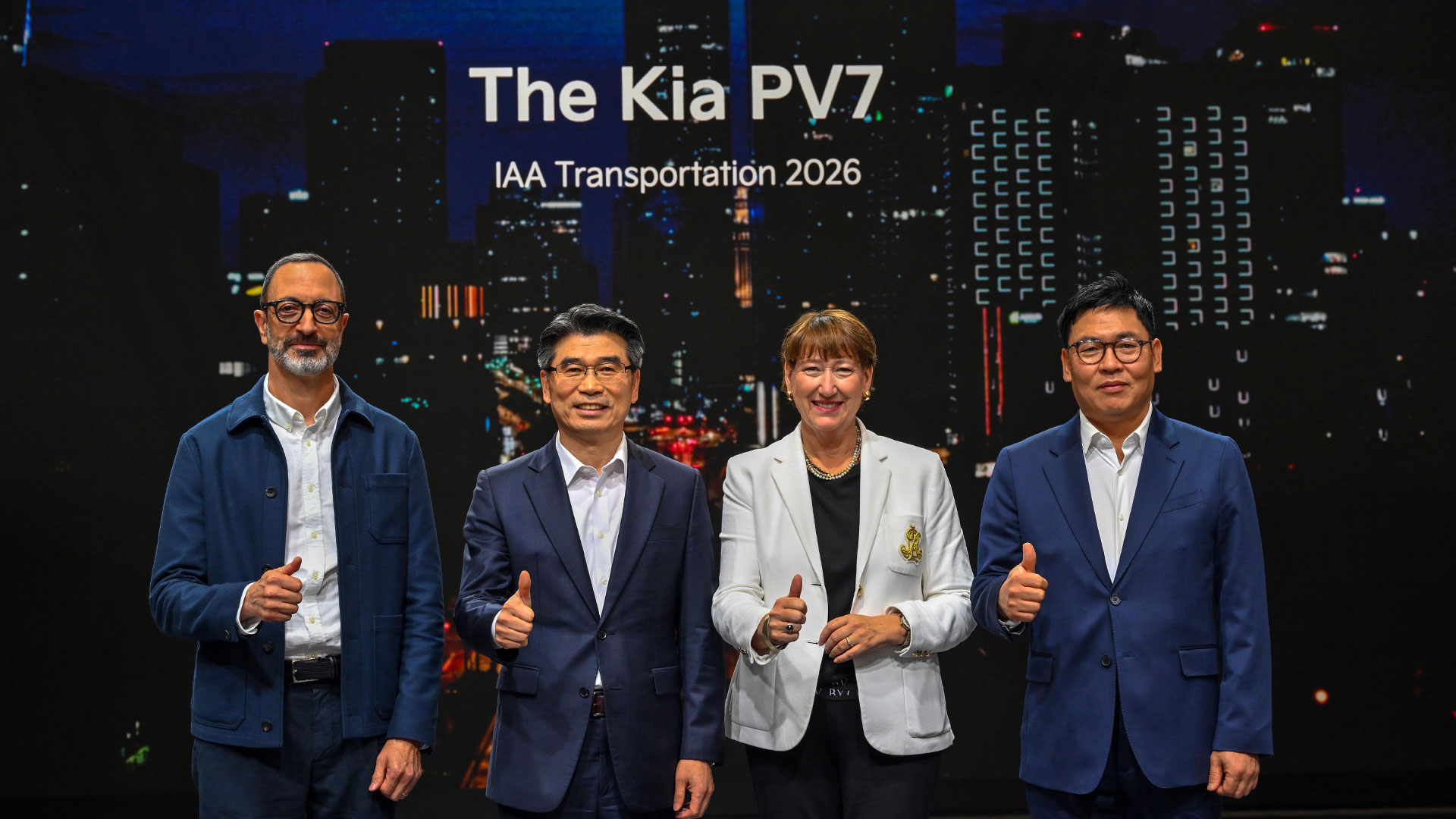 Four executives giving thumbs-up beneath The Kia PV7 presentation screen