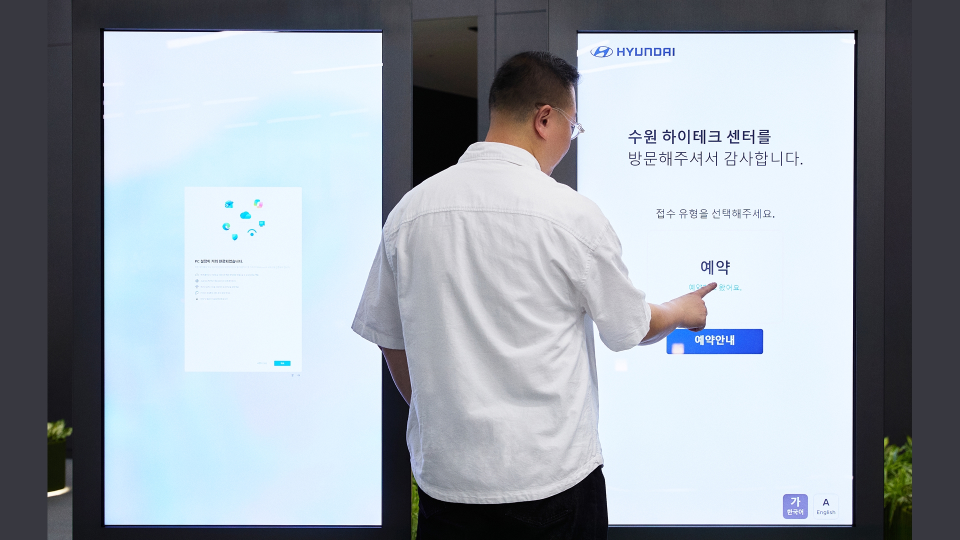 수원하이테크센터 드롭존에 있는 키오스크로 예약한 차량 번호를 입력하는 모습