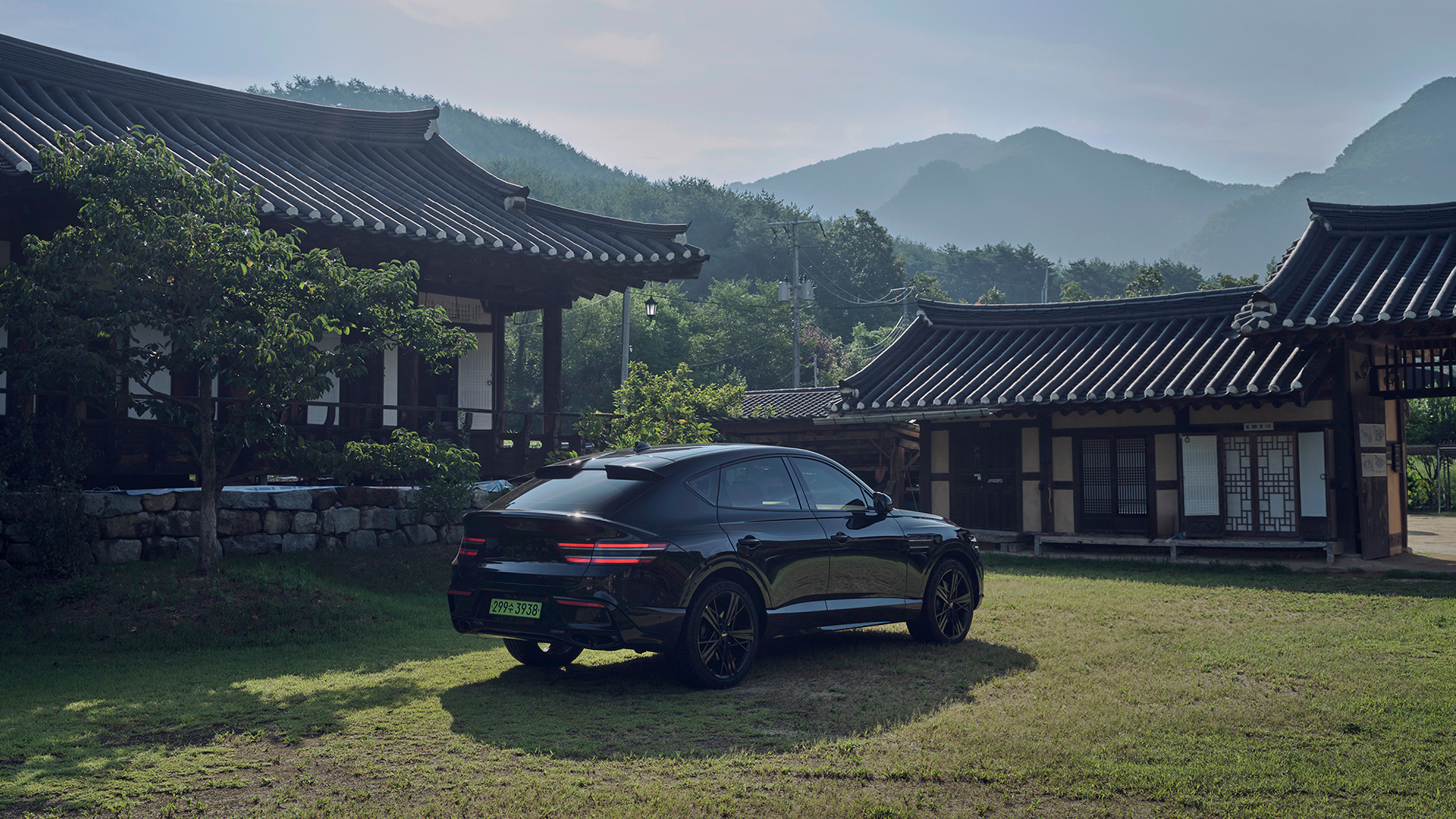 Rear view of the Genesis GV80 Coupe parked in front of a traditional Andong hanok