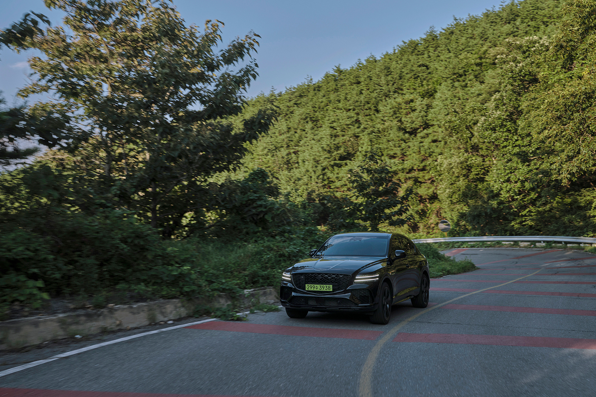 Genesis GV80 Coupe driving along a forest path