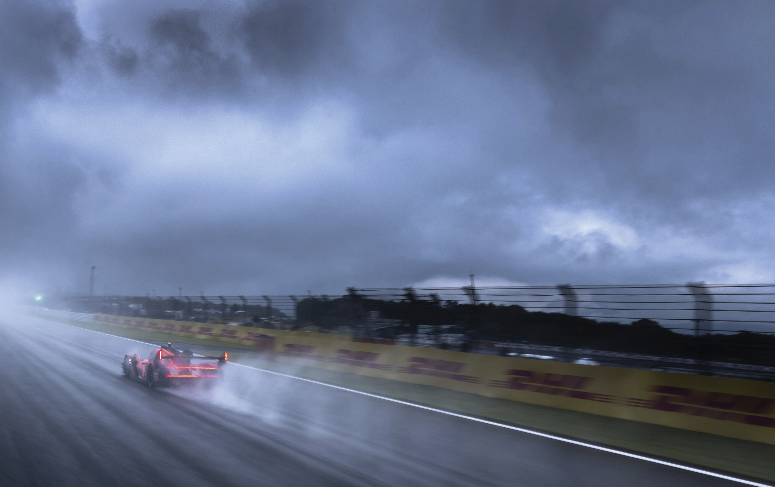 Genesis race car driving through heavy rain