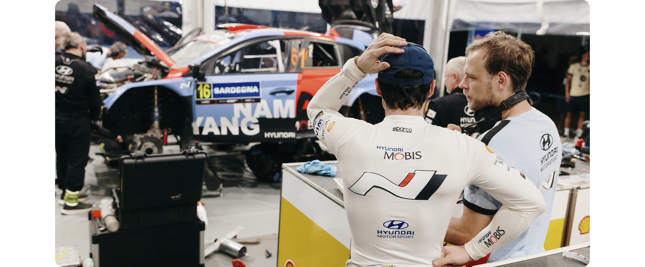 Drivers inspecting rally cars