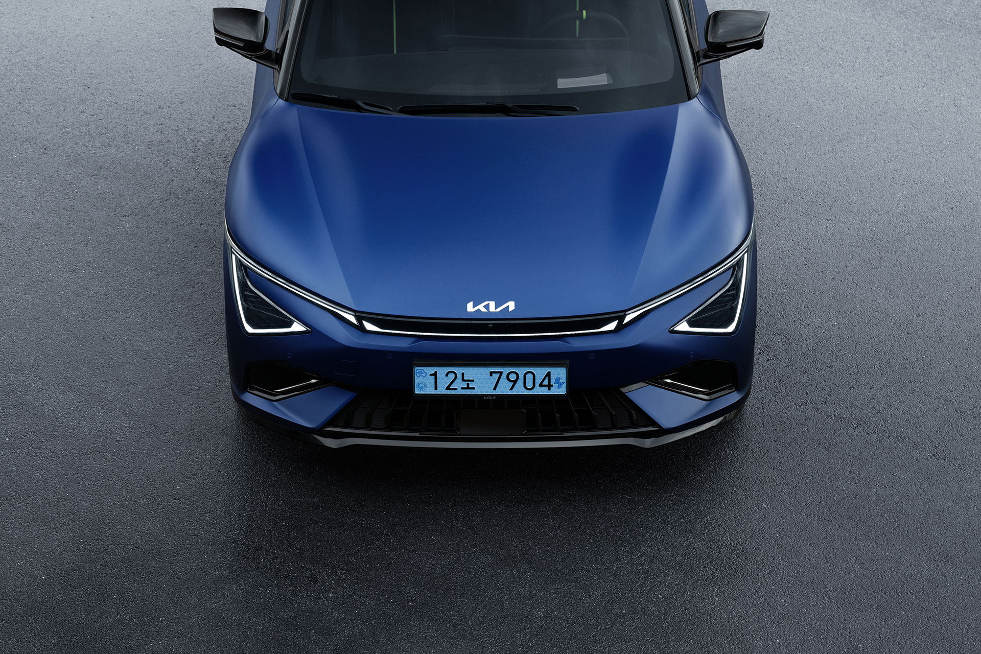 An overhead view of the sharp headlights and hood lines at the front of a blue EV6 GT