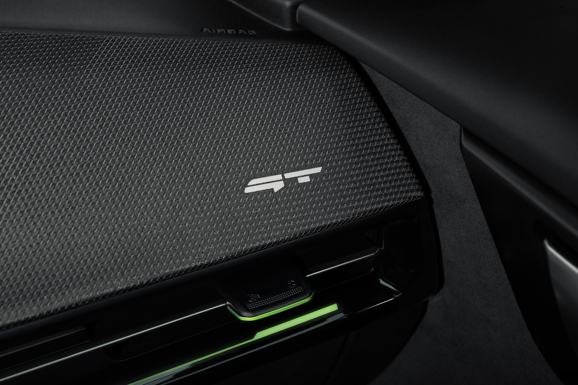 Neon-green ambient lighting and a GT badge beneath the dashboard air vent